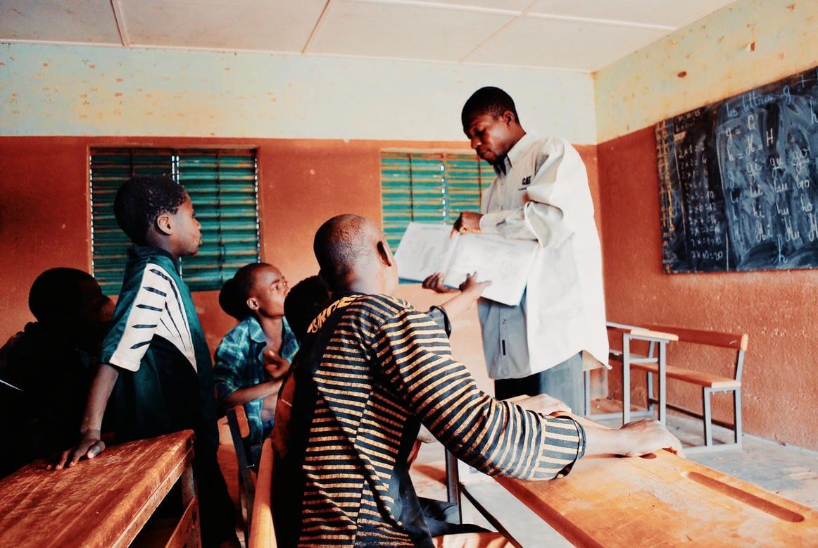 A volunteer teaching a class of children in a schoolroom