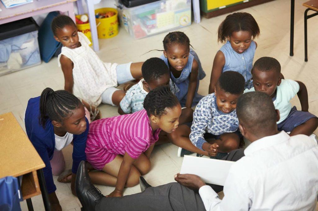 A teacher reading to children in a classroom